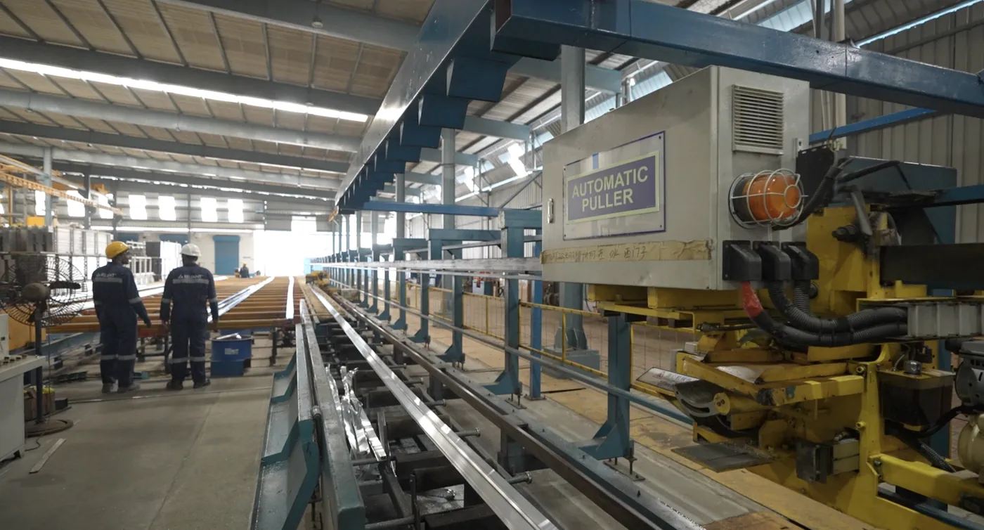 Automatic puller drawing an extrusion along the run-out table